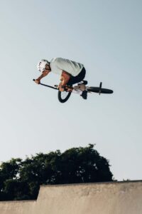young-man-jumping-with-bmx-bike-low-angle-view-1-scaled.jpg